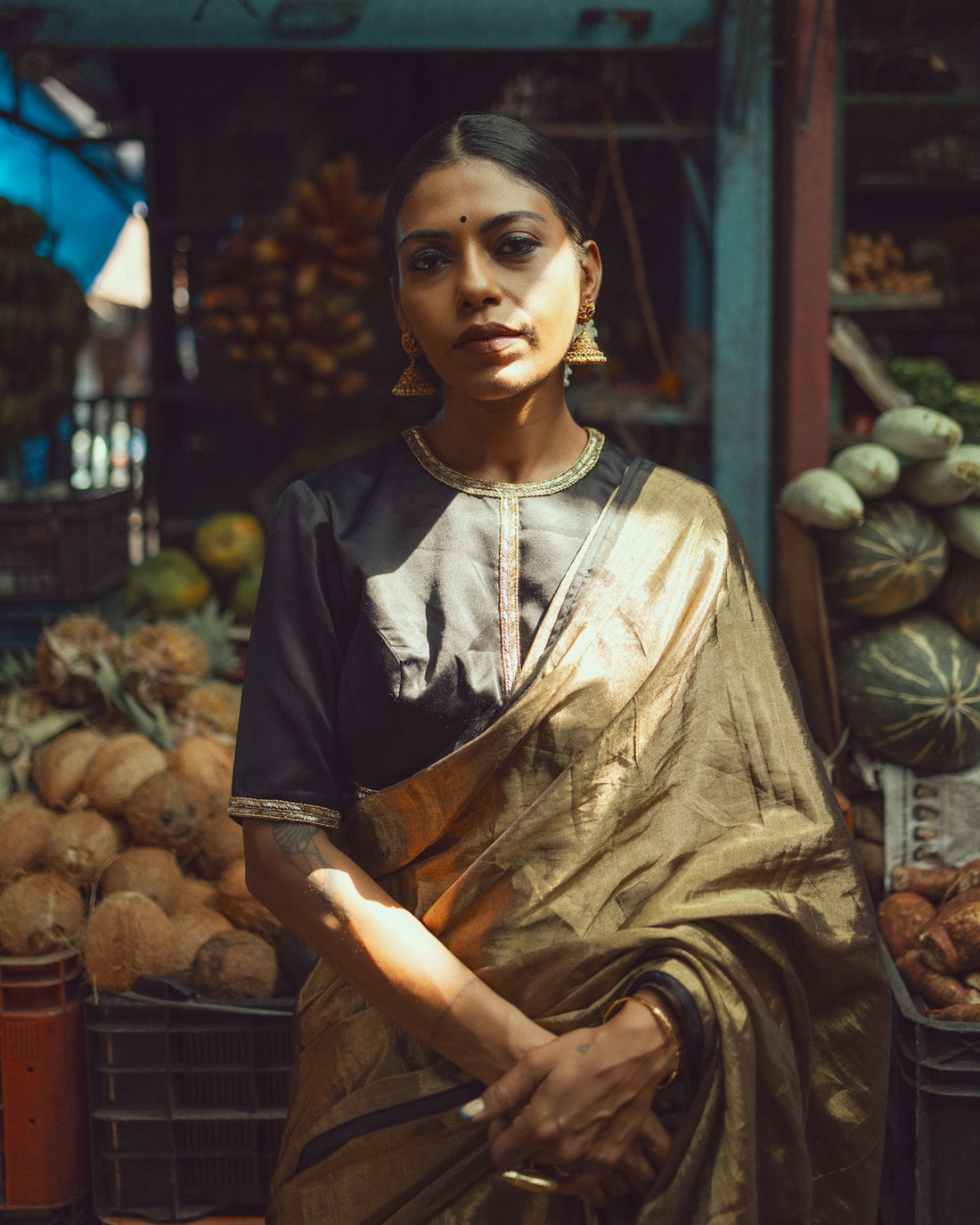 A woman standing in front of a fruit stand