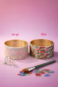 Bindee LoveDrug Bangles and Bindee Revenge Bangles on a pink background with a paintbrush.